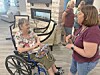 A woman in a wheelchair talks with another woman indoors.