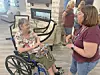 A woman in a wheelchair talks with another woman indoors.