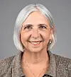 Headshot of a smiling woman with gray hair.