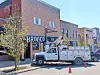 Workers installing a sign at The Bronco with a lift truck.