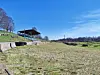 Open field with bleachers and clear blue sky.