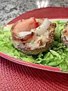 Meatloaf muffins with vegetables on lettuce.