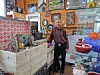 A man stands beside vintage items in an antique shop.