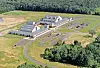 Aerial view of a school building with parking and green fields.