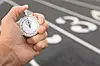 Stopwatch in hand above a running track.