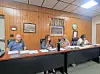 Community board members seated at a table during a meeting.