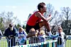 Athlete jumping over a hurdle at a track event.