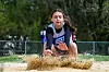 Athlete landing in sand during long jump