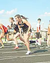 Athletes sprinting on a track field.
