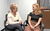 Two women smiling while sitting in chairs.