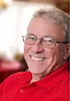 Smiling man in a red shirt with glasses