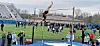 Pole vaulter in mid-air above the bar at a track event.
