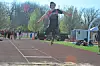 Athlete in mid-air during long jump competition.
