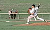 Youth baseball pitcher throwing a ball on a field.