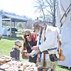 Family with a child interacting with a reenactor outdoors.