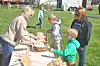Children learning about wool processing at an outdoor event.