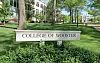 Sign for College of Wooster in a green campus setting.