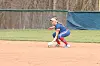 Softball player in blue and red uniform crouching on the field.