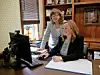 Two women working together at a desk with a computer.