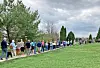 People standing in line outdoors in a park.