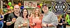 Four people holding drinks at a beer festival.