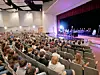 Students seated in an auditorium during a public forum.