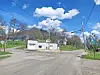 Rural intersection with a white building and blue sky.