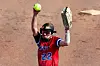 Softball player with a ball in hand, preparing to pitch.