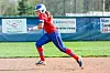 Softball player running on the field in red and blue uniform.