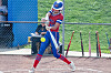 Softball player swinging a bat at a pitch
