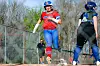 Softball player running towards home plate during a game.