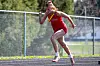 Athlete in red uniform sprinting on track.