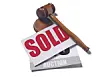 Wooden gavel on a sold sign