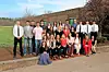 Students in formal attire posing outside a school building.