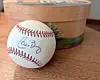 A signed baseball next to a decorative box on a wooden surface.