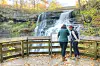 Visitors at a waterfall in autumn.