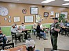 Officer speaking to a group in a diner.
