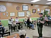 Officer speaking to a group in a diner.