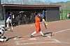 Youth softball player swings at a pitch on the field.