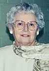 Elderly woman with glasses and a scarf.