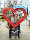 Two women stand in a heart sculpture in Hartville, Ohio.