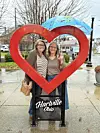 Two women stand in a heart sculpture in Hartville, Ohio.