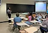Instructor speaking to students in a classroom.