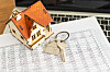 Model house and keys on financial documents