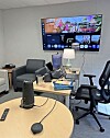 Office meeting room with a large screen and smart devices.