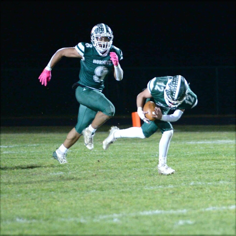 CCM/Carol McIntireMalvern junior Clayton Abel (12) scoops up a Trimble fumble and heads for the end zone in the second quarter Friday. Teamate Rocco Marinucci (9) trails the play.