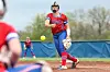 Softball player pitching a ball on a field.