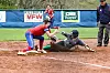 Softball player sliding into home plate with a tag attempt.
