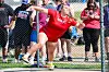 Female athlete in red throwing a discus at a competition.