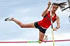 Pole vaulter in action, clearing the bar.